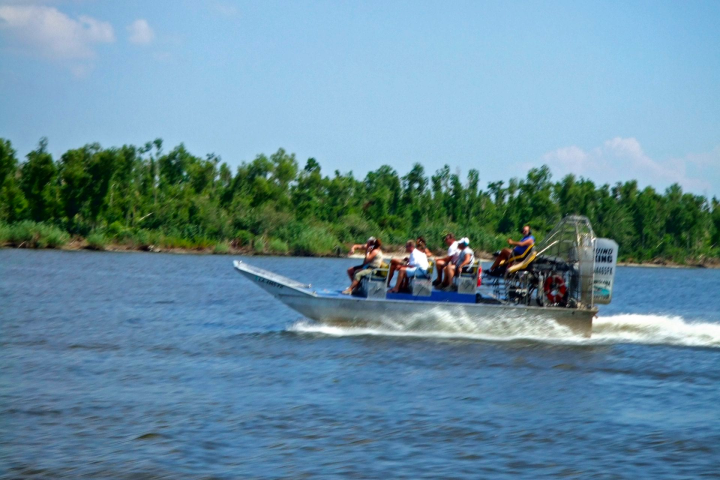 a group of people riding on the back of a boat in the water