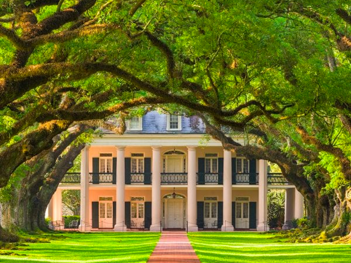 a large brick building with green grass and trees
