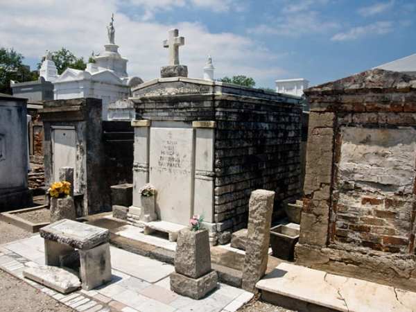 a stone building with Saint Louis Cemetery in the background