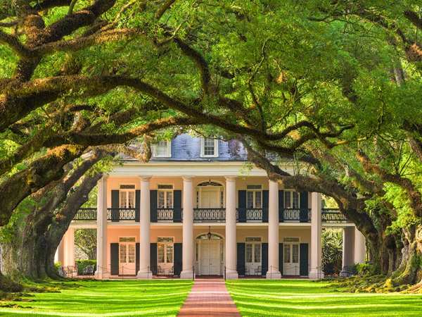 a large brick building with green grass and trees